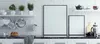 A modern kitchen counter with white subway tiles, shelves with plants and cookware, and two framed pictures on the counter. Produktbild-Vorschau