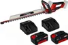 A cordless hedge trimmer, two battery chargers, and two batteries are displayed against a white background. Produktbild-Vorschau