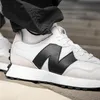A close-up shot of a person wearing New Balance sneakers. Voir les images du produit
