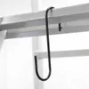 A black S-hook is hanging from a silver ladder rail. Anteprima dell’immagine prodotto