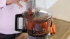 A person is using a food processor to grate carrots. Anteprima dell’immagine prodotto