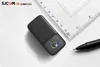 A black SJCAM C200 4K action camera is placed on a white surface next to a ruler and a pen. Produktbild-Vorschau