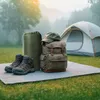 Camping gear laid out on a mat in a misty outdoor setting with a tent in the background. Náhľad obrázku produktu