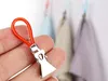 A hand holding a red towel loop with a silver clip attached. In the background, several towels are hanging. Anteprima dell’immagine prodotto