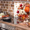 A kitchen scene with a glass cutting board featuring a fall harvest theme displayed on a stovetop. Náhled obrázku produktu