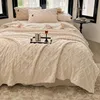 A cozy bed with a thick, cable-knit blanket, pillows, and a small tray with a drink and gift. Anteprima dell’immagine prodotto