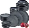 A collection of dark gray ceramic plates and bowls are stacked and arranged on a white background. Two pomegranates are placed in the foreground. Produktbild-Vorschau