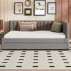 A gray upholstered daybed with a mattress and pillows is shown in a room with framed pictures on the wall and a patterned rug on the floor. Náhľad obrázku produktu