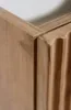 A close-up view of the corner of a wooden cabinet with fluted detailing. Produktbild-Vorschau