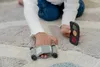 A child's hands playing with toy cars and a traffic light on a rug. Voir les images du produit