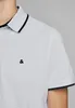 Close-up of a person wearing a light gray polo shirt with black trim on the collar and sleeves. A small black logo is visible on the chest. Produktbild-Vorschau