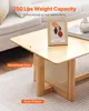 A close-up of a wooden coffee table with rattan accents, placed on a rug next to a sofa. Produktbild-Vorschau