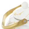 A close-up shot of a white kettle with gold marbling and a gold handle. Podgląd zdjęcia produktu