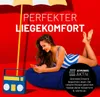A woman is lying on a large navy blue beanbag chair, looking at her phone. A vintage-style radio is next to her. A yellow and white umbrella is overhead. The background is red. Produktbild-Vorschau