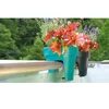 Two balcony planters with plants are attached to a railing, with a blurred forest background. Produktbild-Vorschau