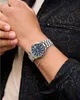 A close-up shot of a person's wrist wearing a silver watch with a blue face and a thin silver bracelet. Podgląd zdjęcia produktu