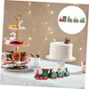 A festive Christmas table setting with a cake, cupcakes, and decorative elements. Náhled obrázku produktu
