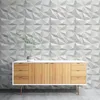 A modern sideboard with wooden drawers and doors stands against a textured concrete wall. Anteprima dell’immagine prodotto