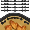 The top part of the image shows four sets of black silicone magnetic fasteners. The bottom part shows a close-up of an air fryer basket with cooked chicken wings inside, with some of the fasteners attached to the basket's rim. Produktbild-Vorschau