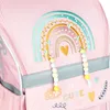 Close-up of a pink backpack with a rainbow design and beaded charms. Voir les images du produit