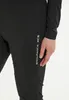 A close-up shot of a person wearing black pants with white text on the side. Produktbild-Vorschau
