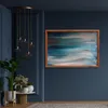 A painting hangs on a dark blue wall above a small table with plants. Produktbild-Vorschau
