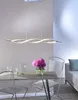 A dining table with chairs and a modern pendant light. Náhled obrázku produktu