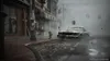 A foggy, wet street scene in a city with a vintage car. Podgląd zdjęcia produktu