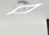A modern LED ceiling light fixture with a curved, two-flame design, mounted on a white ceiling. Produktbild-Vorschau