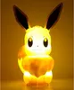 A lit-up Eevee Pokemon lamp against a yellow background. Náhľad obrázku produktu