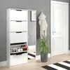 A white shoe cabinet with a mirror is shown in a hallway next to a white door and a potted plant. Produktbild-Vorschau