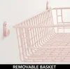 Close-up view of a pink wire storage basket mounted on a wall with a hook. Produktbild-Vorschau