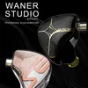 A close-up marketing image of two in-ear monitor headphones against a black, wavy background. Produktbild-Vorschau