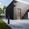 A modern house exterior with a pathway leading to the entrance, featuring a bicycle parked nearby. Produktbild-Vorschau