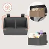 A collage of images showing a gray baby organizer with different contents and attached to a crib. Produktbild-Vorschau