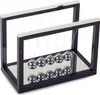 A Newton's cradle toy with multiple metallic spheres suspended from a black frame with a mirrored base. Náhľad obrázku produktu
