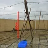 A water pump setup on a wet tiled surface, with a red arrow indicating height. Podgląd zdjęcia produktu