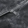 A close-up view of a zipper on a dark gray, fuzzy fabric. Produktbild-Vorschau