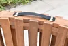 A close-up view of a black fabric handle with gold clasps attached to a wooden structure. Náhled obrázku produktu