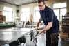 A man is using a table saw in a workshop. Podgląd zdjęcia produktu