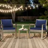 Two rocking chairs with dark blue cushions and a small side table on a wooden deck at dusk, with string lights overhead. Produktbild-Vorschau