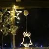 Christmas decorations hanging in a window at night. Podgląd zdjęcia produktu