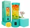 A teal BlendyGo 3 portable blender filled with citrus fruits and oranges, displayed next to its packaging and a sliced lemon. A flower is also visible. Náhľad obrázku produktu