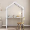 A child's desk shaped like a house, with art supplies and a lamp on the desk, and a chair next to it. Produktbild-Vorschau