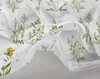 A close-up view of a white duvet cover with a green floral pattern and a partially opened zipper. Produktbild-Vorschau