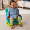 A baby sitting in a colorful toy chair. Anteprima dell’immagine prodotto