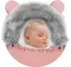 A sleeping baby in a pink stroller sack with a gray fur trim and pink bear ears. Produktbild-Vorschau