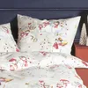 A close-up view of a bed with pillows and a duvet cover featuring a winter-themed pattern of snowmen and red berries. Produktbild-Vorschau