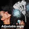 A woman is enjoying a shower with water spraying from a showerhead. Produktbild-Vorschau