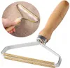 A hand is holding a lint remover over a carpet. Produktbild-Vorschau
